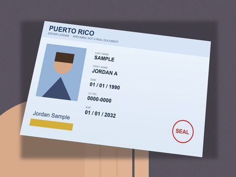 Before: Specimen driver licence held in a hand, tilted, dark background.